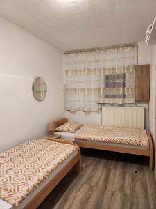 2 camas en una habitación con ventana en Apartma Maka, en Maribor
