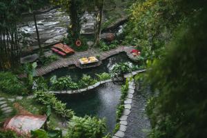a model of a garden with a bridge over a river at Bambu Indah in Ubud