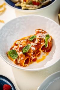 a white plate of pasta with basil on it at The Ritz-Carlton Shanghai, Pudong in Shanghai
