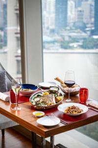 a table with plates of food and glasses of wine at The Ritz-Carlton Shanghai, Pudong in Shanghai