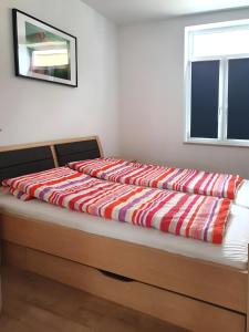 a bed with a red and white blanket on it at Geräumige moderne 3 Raumwohnung in Dohna