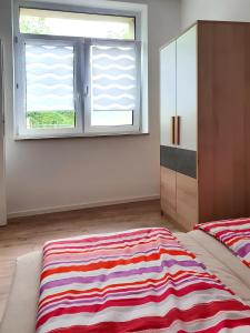 a bedroom with a striped rug on the floor next to a window at Geräumige moderne 3 Raumwohnung in Dohna