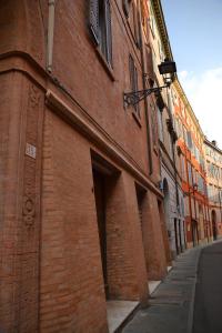 un edificio di mattoni rossi con un vicolo accanto a una strada di Dimora Castelmaraldo a Modena