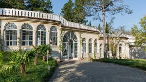 a large building with large windows and a driveway at Legends Tskaltubo Spa Resort in Tsqaltubo