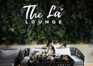 a woman sitting at a table with food on it at Paragon Saigon Hotel in Ho Chi Minh City