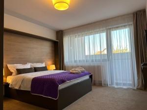 um quarto com uma cama grande e uma janela grande em Luxury Glam Apartments & Studios near Coresi Mall em Brasov