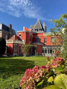 Maison Manotte d’Artois في أراس: منزل احمر كبير وامامه زهور