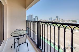 a balcony with a table and a view of the city at Vivid 2BR at Canal Residences West Dubai Sports City by Deluxe Holiday Homes in Dubai