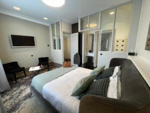 a bedroom with a large bed and a couch at Maison Manotte d’Artois in Arras