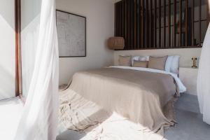 a bedroom with a large bed with white sheets and pillows at MAE Villas Canggu in Canggu
