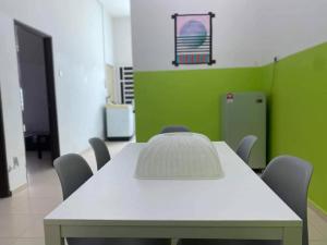a white table and chairs in a room with green at 3 rooms (aircond) in Muar Town in Muar
