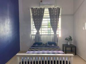 a bedroom with a white crib and a window at 3 rooms (aircond) in Muar Town in Muar