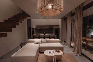 a living room with a white couch and a table at MAE Villas Canggu in Canggu