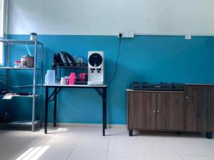 a room with a table and a blue wall at 3 rooms (aircond) in Muar Town in Muar