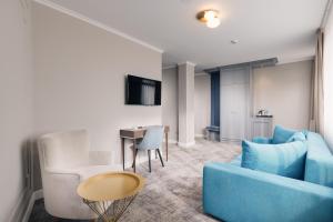 un soggiorno con divano blu e tavolo di Hotel Meridian a Cluj-Napoca