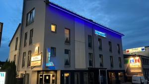 a building with a blue sign on the side of it at Hotel Come In in Menden