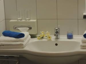 a bathroom with a sink with towels and a mirror at Appartement Bürgerbräu Hermagor in Hermagor