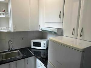 a kitchen with white cabinets and a microwave at Estudio en Plaza del Callao Madrid Xs in Madrid