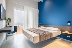 um quarto com uma cama grande e uma parede azul em Marino1958 RTA em Numana