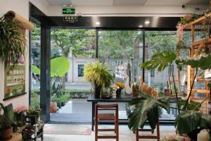 una habitación con una mesa y algunas plantas en City Park Hotel en Shanghái