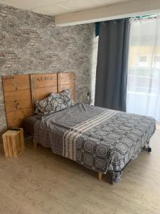 um quarto com uma cama e uma parede de tijolos em Suite parentale 50m2 em Châtillon-Saint-Jean