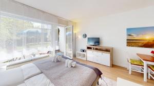 um quarto com uma cama e uma grande janela em NeuKlosterhof App. 06 em Pelzerhaken