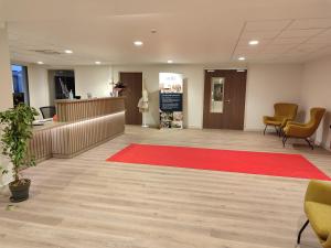 an office lobby with a red rug and a waiting room at Zenao Appart'hôtels Montivilliers in Montivilliers