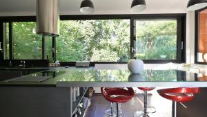 une cuisine avec une grande fenêtre et des tabourets rouges dans l'établissement BISCALODGE, à Biscarrosse