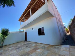 a large white building with a roof at Suite casal na praia do Preá in Cruz
