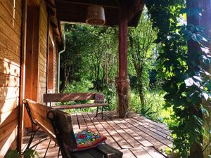 a porch with a bench and a chair on it at Butterfly Factory in Jonkowo