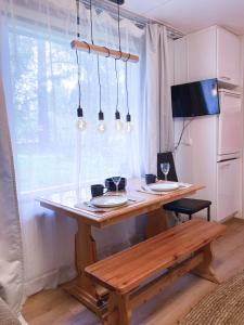 una mesa de madera con platos junto a una ventana en The Blueberry Inn en Rovaniemi