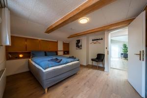1 dormitorio con 1 cama y 1 silla en Large apt in town center with garden & near lake, en Brienz