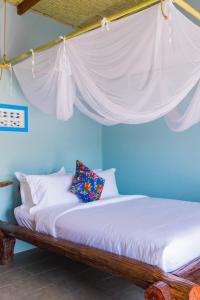 a bedroom with a bed with a white canopy at La Mer - Vĩnh Hy bay - beachfront villa CHÀI in Vĩnh Hy