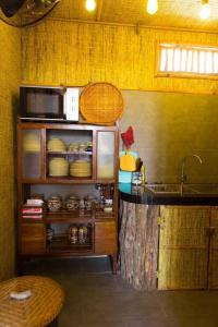 eine Küche mit einer Theke, einer Spüle und einer Arbeitsplatte in der Unterkunft La Mer - Vĩnh Hy bay - beachfront villa CHÀI in Vĩnh Hy