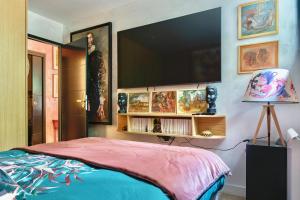 een slaapkamer met een bed en een tv aan de muur bij The Iflissen Nest - Luxury Appartment in Lamorlaye