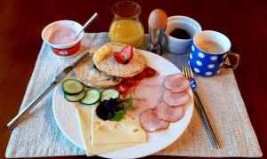 a plate of food with meat and cheese on a table at Spa Park Guest Rooms in Długopole-Zdrój