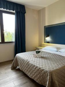 a bedroom with a bed and a large window at Il Grifo Hotel e Bisteccheria Toscana in Montepulciano