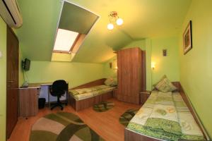 a bedroom with two beds and a desk and a window at Pensiunea Radena in Arad