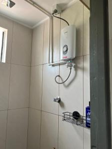 a shower in a bathroom with a white tiled wall at Samah Apartments in Mba
