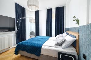 um quarto com uma cama com um cobertor azul em Grand Tulipan em Gdynia