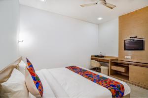 Cette chambre comprend un lit et une télévision. dans l'établissement FabExpress Vasundhara Suits, à Ghaziabad