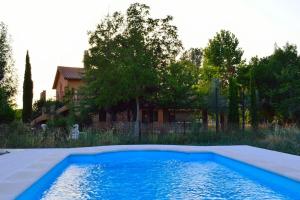 a blue swimming pool in front of a house at Granja de Cantarinas in Ciudad-Rodrigo