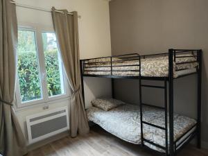 een slaapkamer met 2 stapelbedden en een raam bij Le Cottage Senlisien in Senlis
