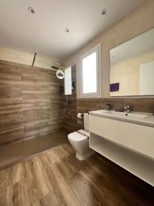 a bathroom with a toilet and a sink and a mirror at Apartamentos El Bergantin Menorca Club in Fornells