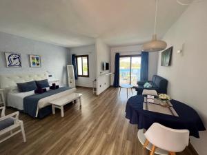 a bedroom with a bed and a living room at Apartamentos El Bergantin Menorca Club in Fornells