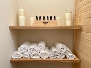 a shelf with towels and candles in a bathroom at Feng Shui Vila u zámecké zahrady Konopiště in Bystřice