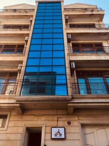 ART inn hotel في باكو: مبنى زجاجي طويل مع وضع علامة عليه