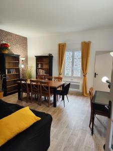 een woonkamer met een eettafel en stoelen bij Le Cottage Senlisien in Senlis