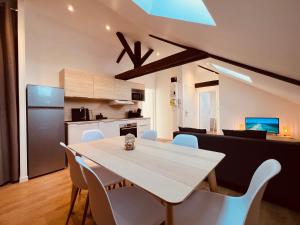 a kitchen and dining room with a white table and chairs at L'Ibiza in Montluçon