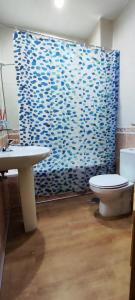 baño con aseo y cortina de ducha azul en Hostal Hotel EL Chato en El Barraco